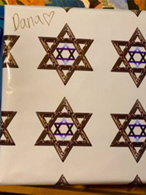 An unopened gift wraped with the Star of David wrapping paper. Next Avenue, layoff, laid off