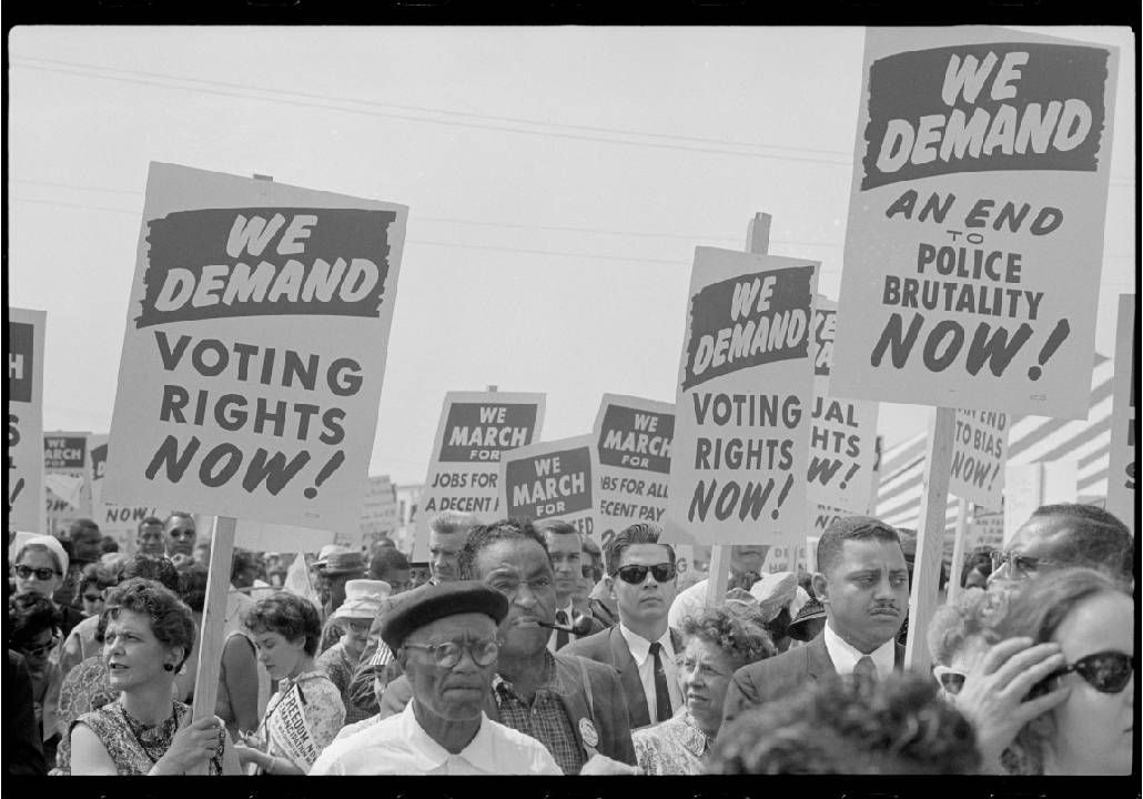 A black and white photograph of demonstrators holding up protest signs during the march on washington. Next Avenue, Black led social movements, ageism,