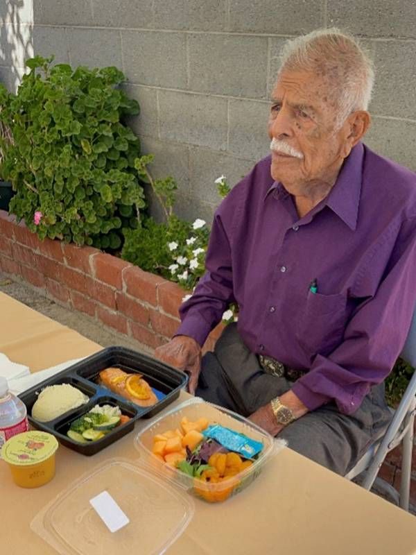 An older adult sitting at a table with a meals on wheels kit in front of him. Next Avenue, Older Americans Act Nutrition Program 50 years, meals on wheels