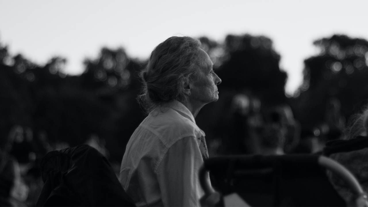 A black and white photo of an aolder adult looking out into the distance. Next Avenue, covid impacts on dementia, isolation