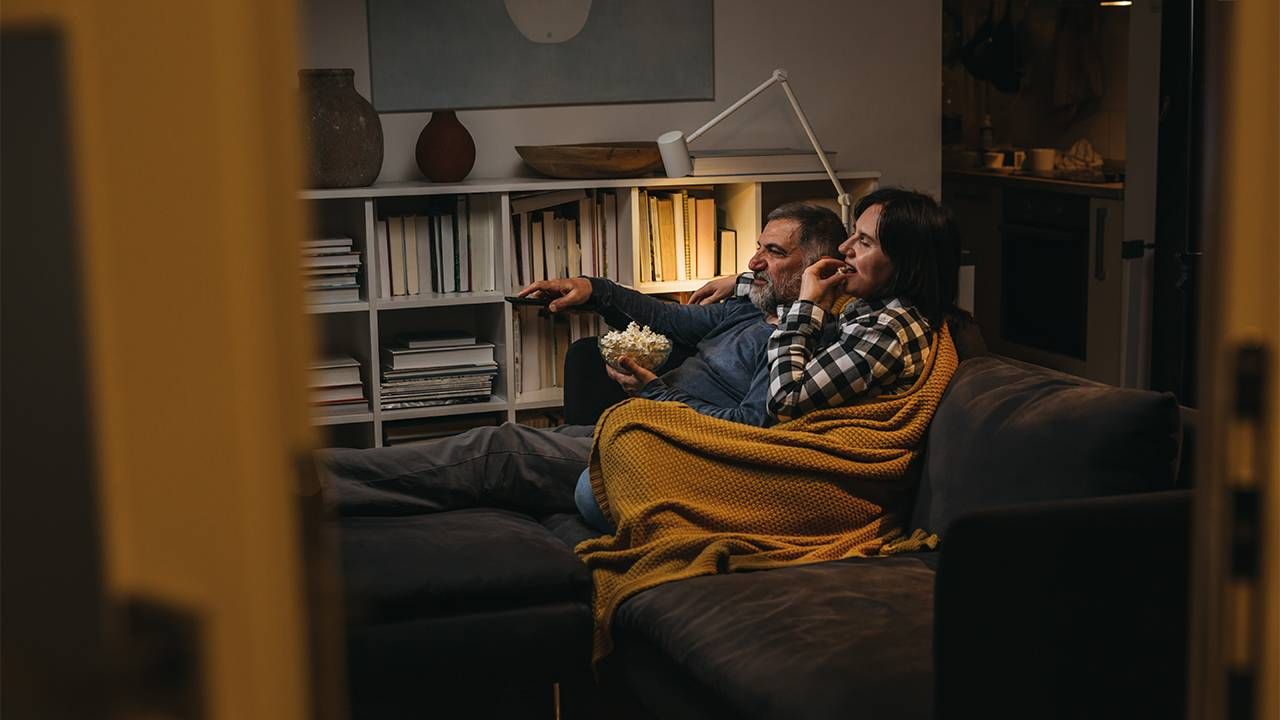 An older couple at home watching TV from the couch. Next Avenue, hearing issues at home