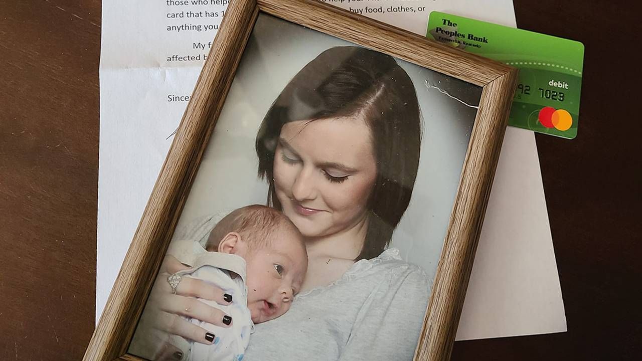 A framed photograph, a gift card and a letter on top of a table. Next Avenue, kentucky tornado belongings