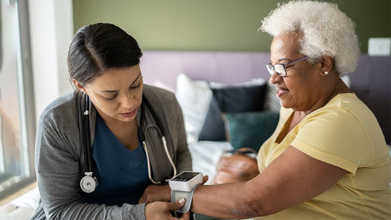 A home care nurse taking an older adult patient's blood pressure. Next Avenue, low blood pressure