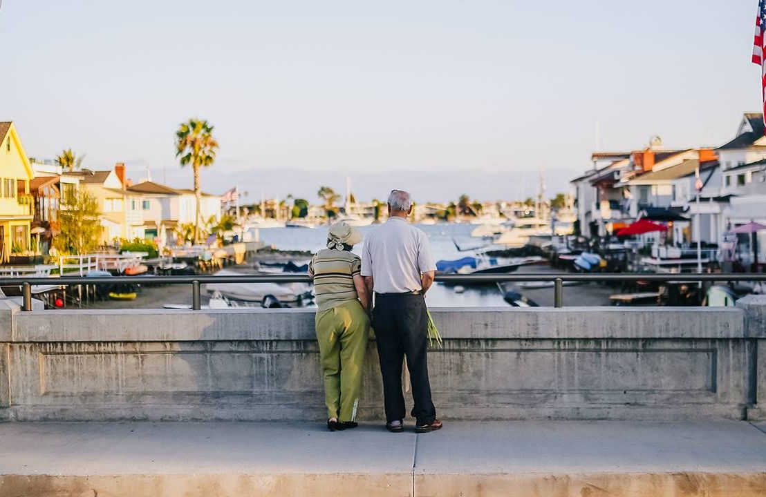 An older couple looking out at a canal. Next Avenue, mental health benefits