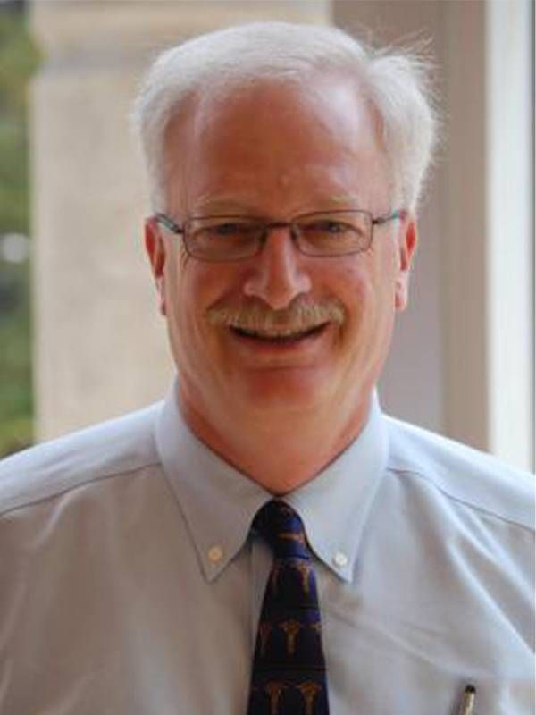 A man wearing a button up shirt and tie smiling. Next Avenue, bereavement, grief, widow