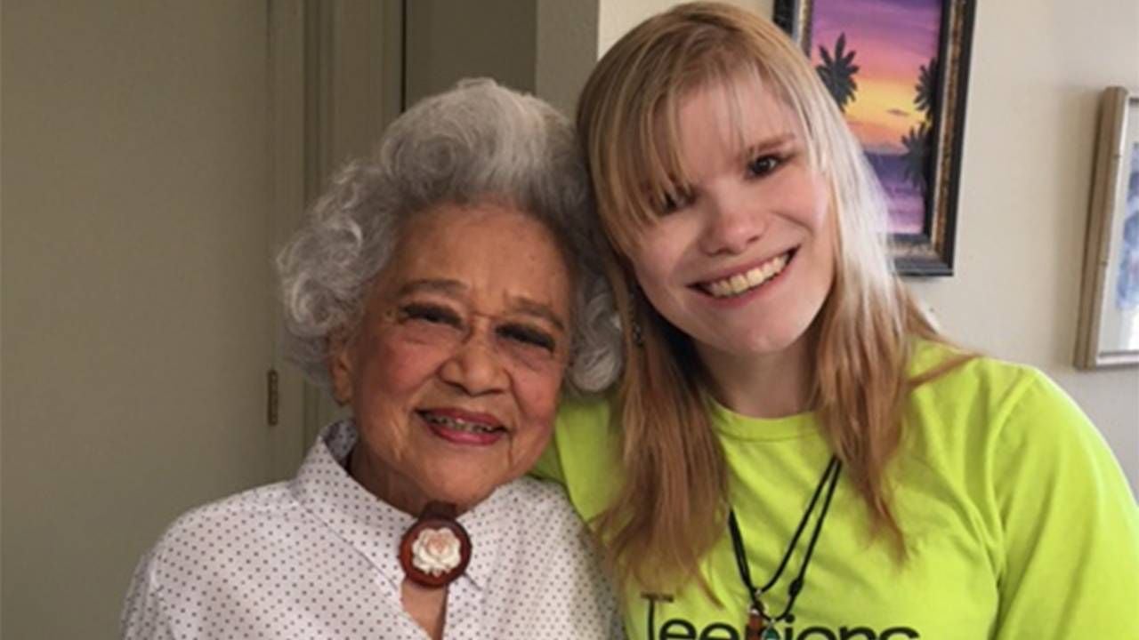 An older adult and young person standing together and smiling. Next Avenue, intergenerational friendship