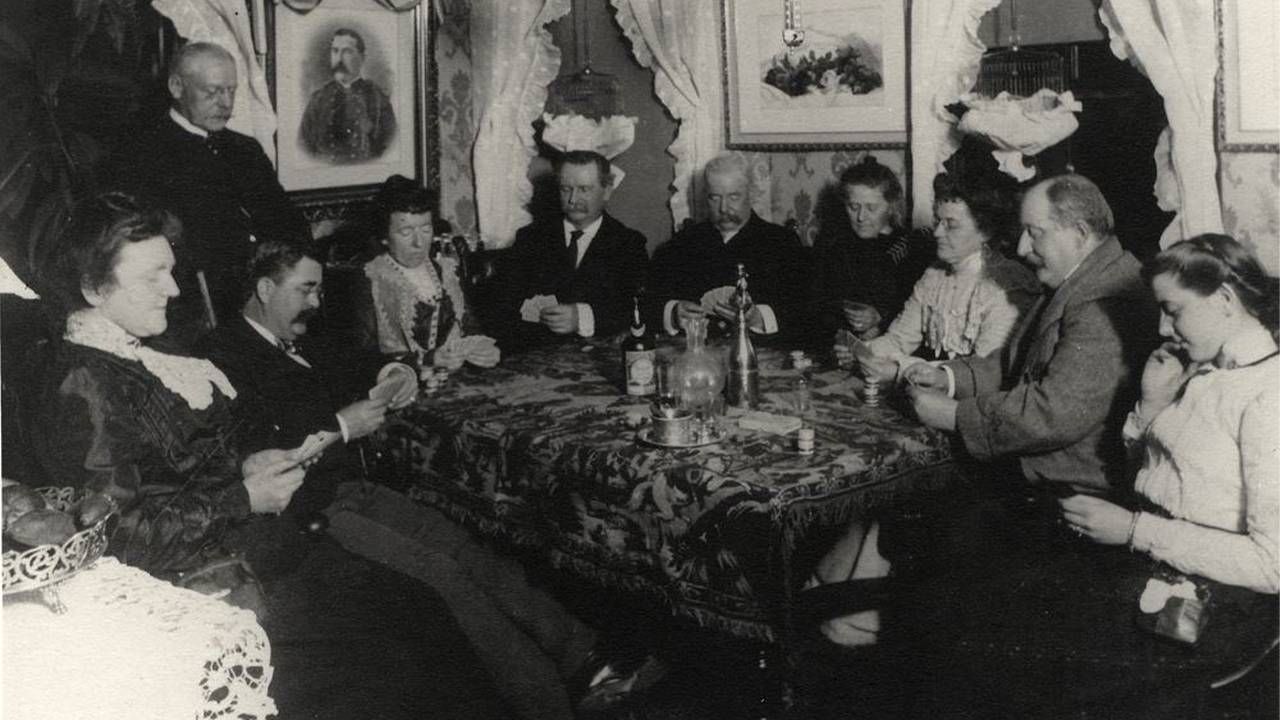 A black and white photo of people playing cards at a table. Next Avenue, The First Kennedys