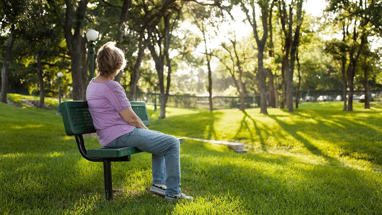 An older adult sitting on a park bench looking off into the distance. Next Avenue, husband is gay