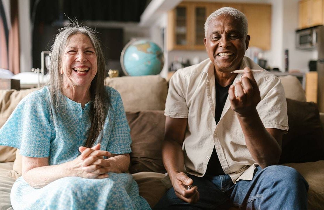 Two older adults smiling and holding up a joint. Next Avenue, marijuana, weed, older adults, seniors