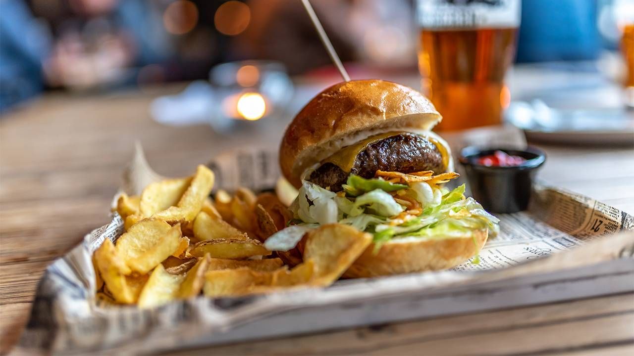 A burger on a tray at a restaurant meeting about cremation preplanning. Next Avenue