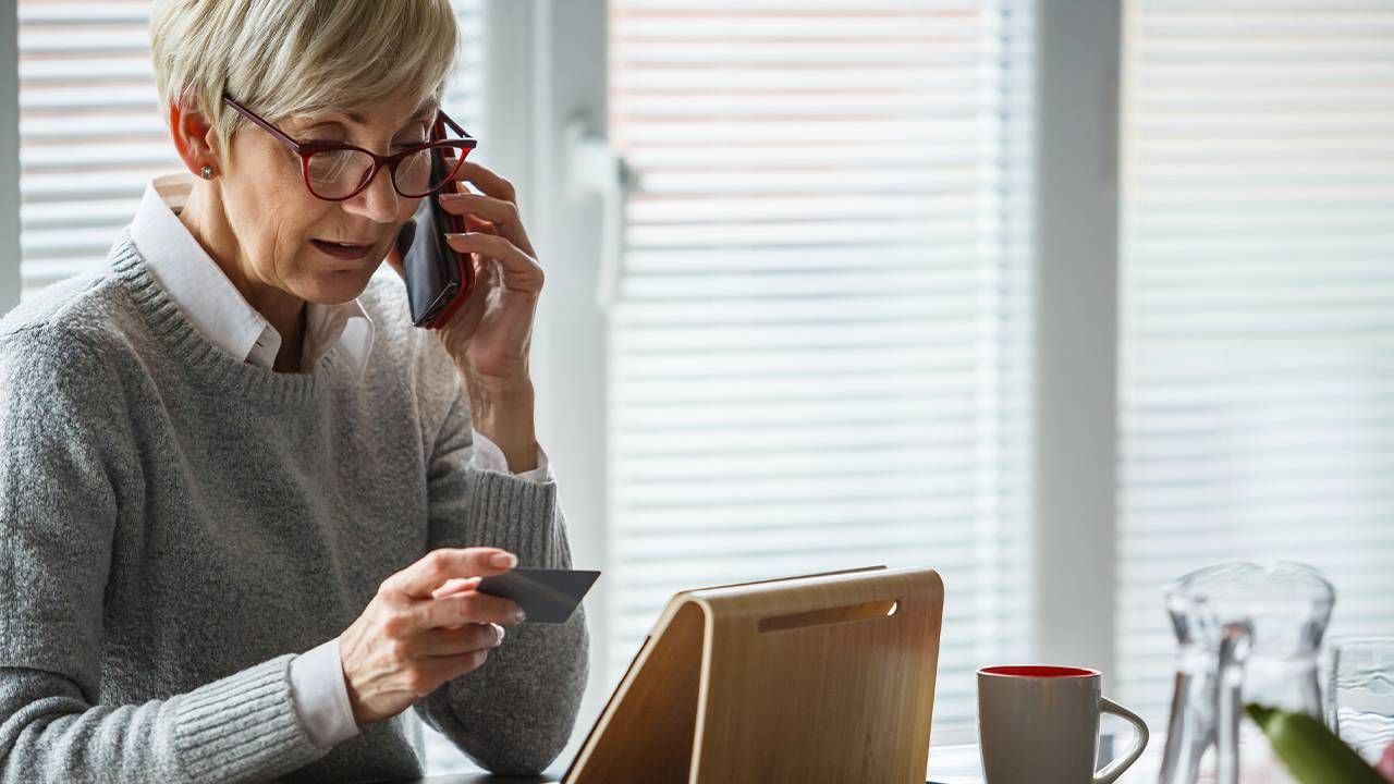 An older adult calling the bank about a credit card scam. Next Avenue