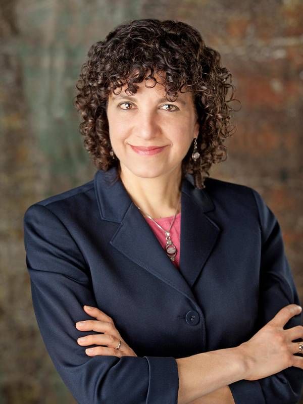 A woman with curly hair smiling. Next Avenue, overcoming age bias