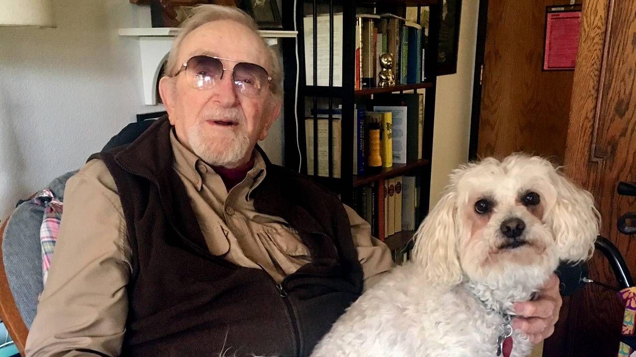 An older adult sitting with his dog on his lap. Next Avenue, medical aid in dying