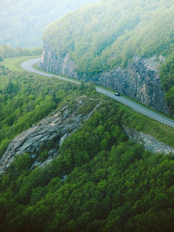 A winding road through a forested mountain. Next Avenue, places to travel during pandemic