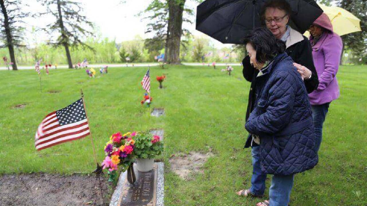 Two people visiting a gravesite. Next Avenue, adoptee story, memorial day