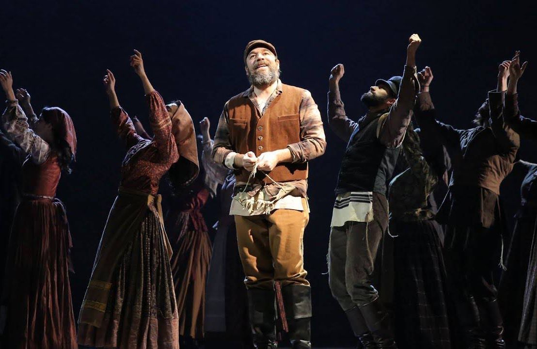 A cast of actors in the musical Fiddler on the Roof standing on stage. Next Avenue, solo agers, traditions