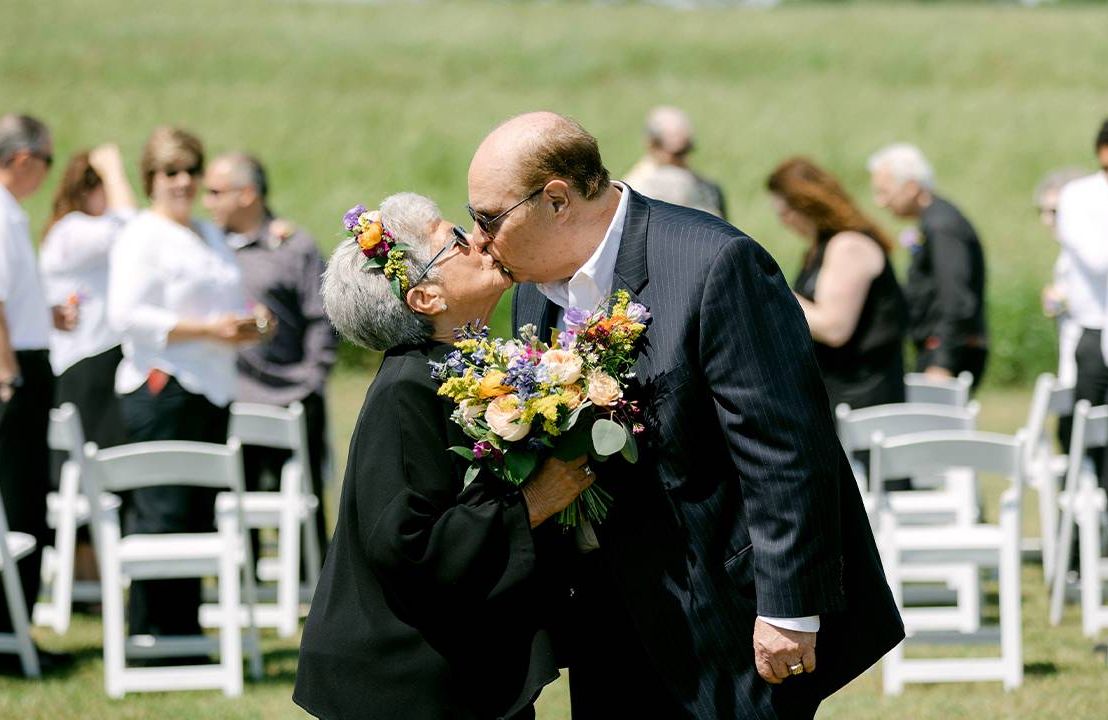 A couple kissing on their wedding day. Next Avenue, Marrying married later in life