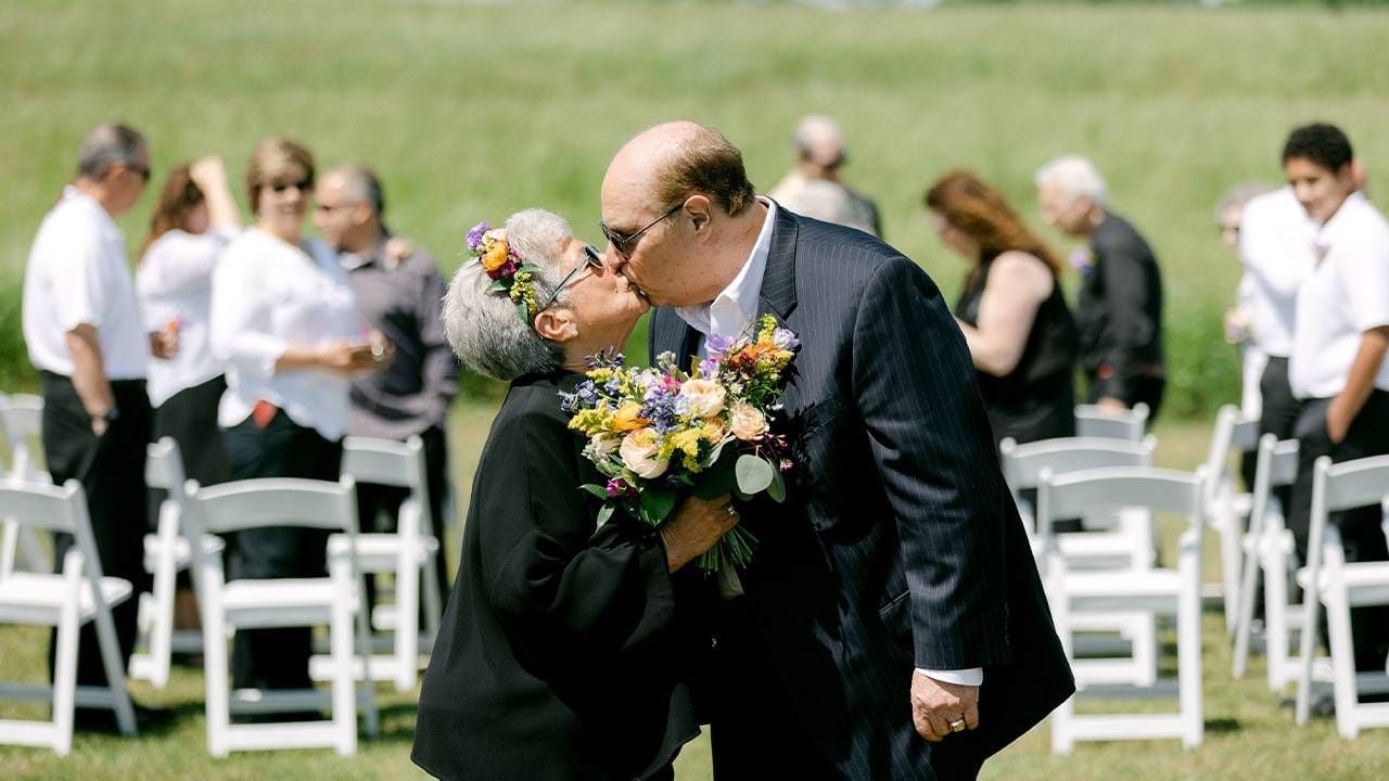 A couple kissing on their wedding day. Next Avenue, Marrying married later in life