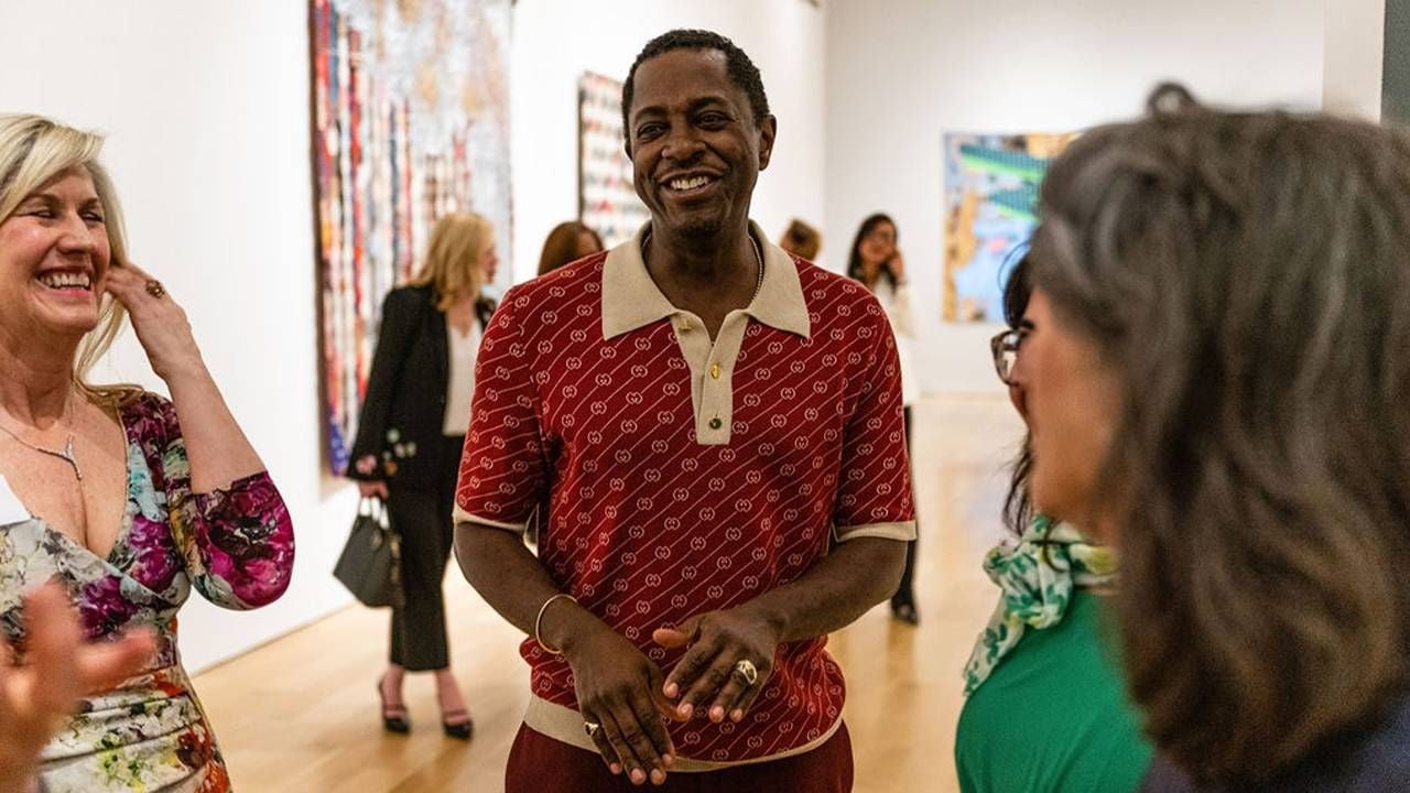 A group of people laughing inside a museum. Next Avenue, contemporary quilts