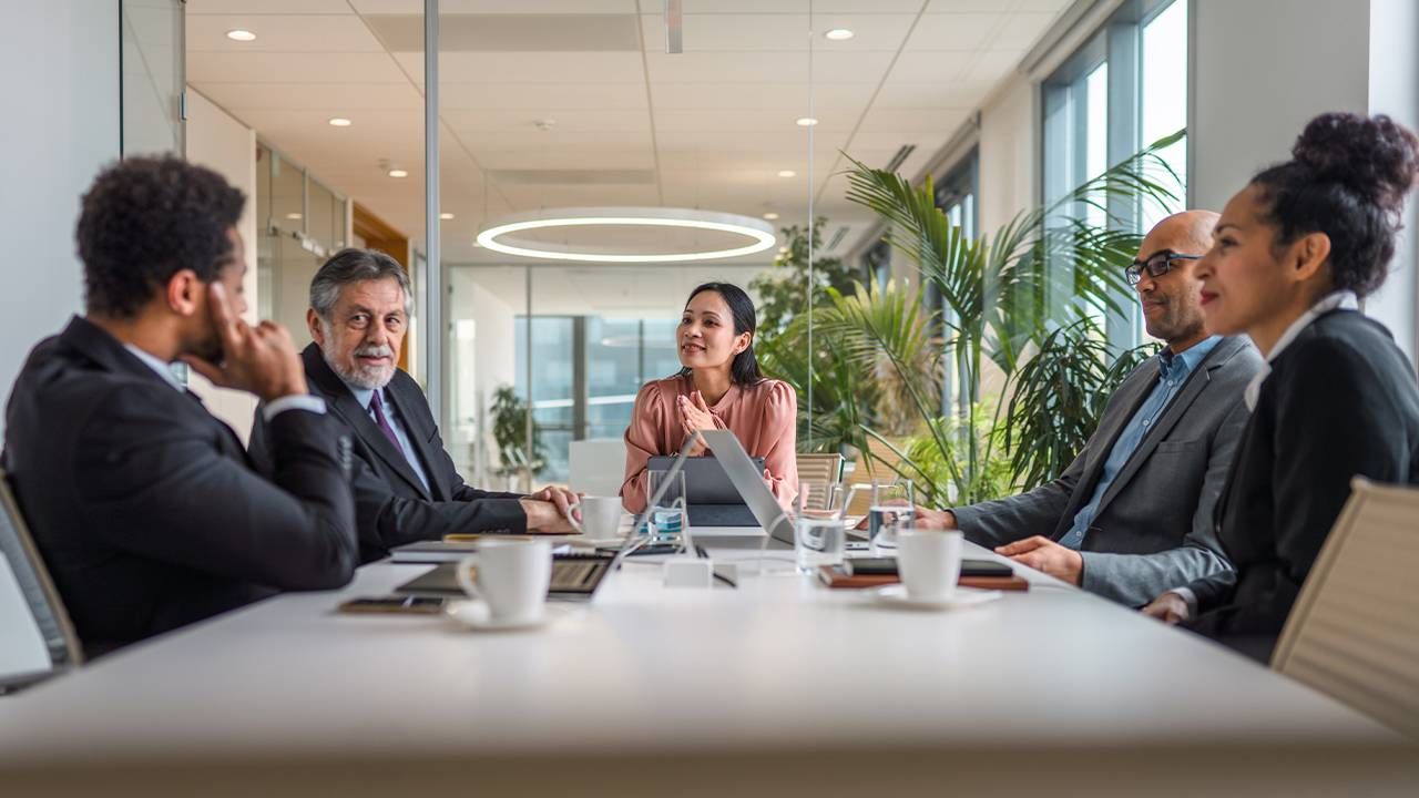 A diverse group of adults talking during a corporate board meeting. Next Avenue