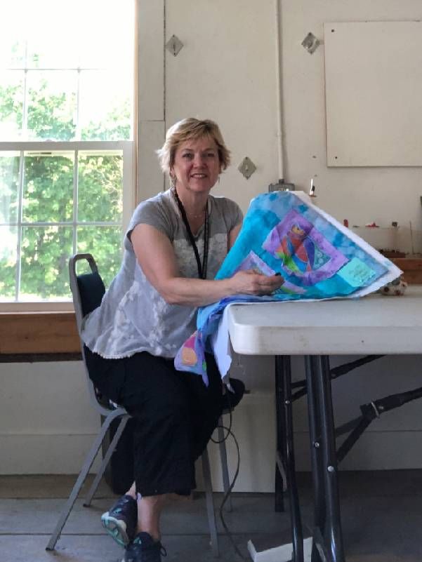 An older adult works on a blue quilt. Next Avenue, crafts older adults, craft schools