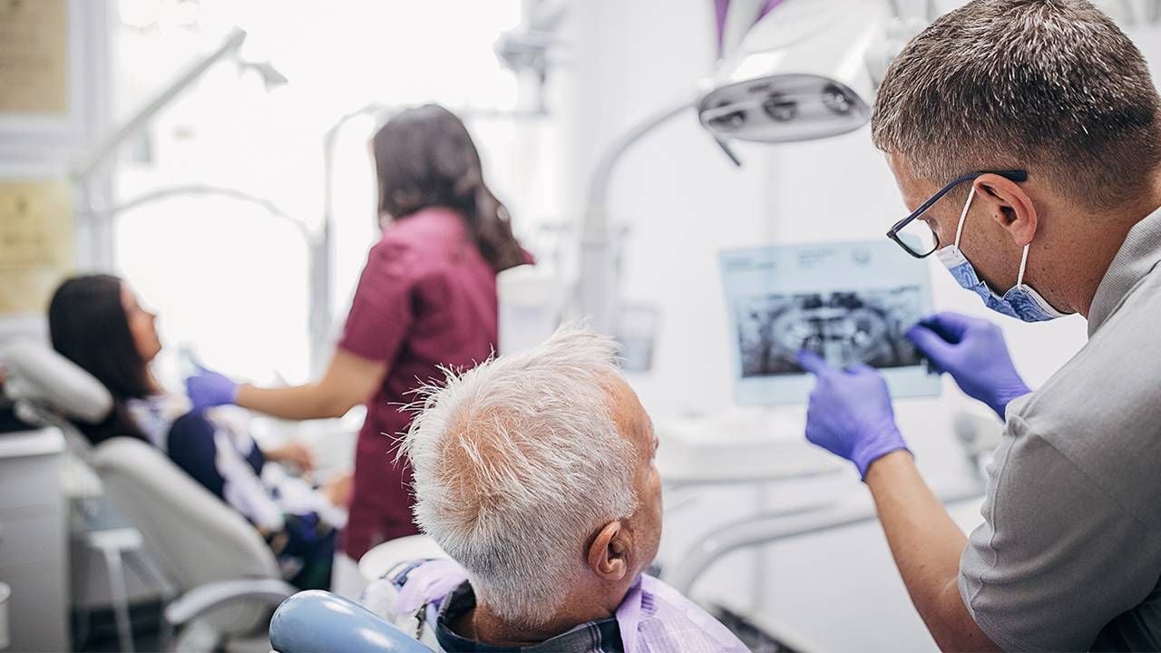 A dentist explaining denture work. Next Avenue, what is it like to have dentures