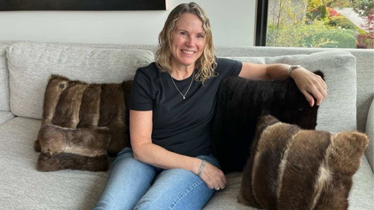 A woman sitting on a couch with fur pillowcases. Next Avenue, what to do with old fur coats