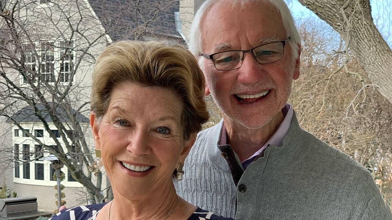 A smiling couple outside their home. Next Avenue, journey with Alzheimer's, dementia