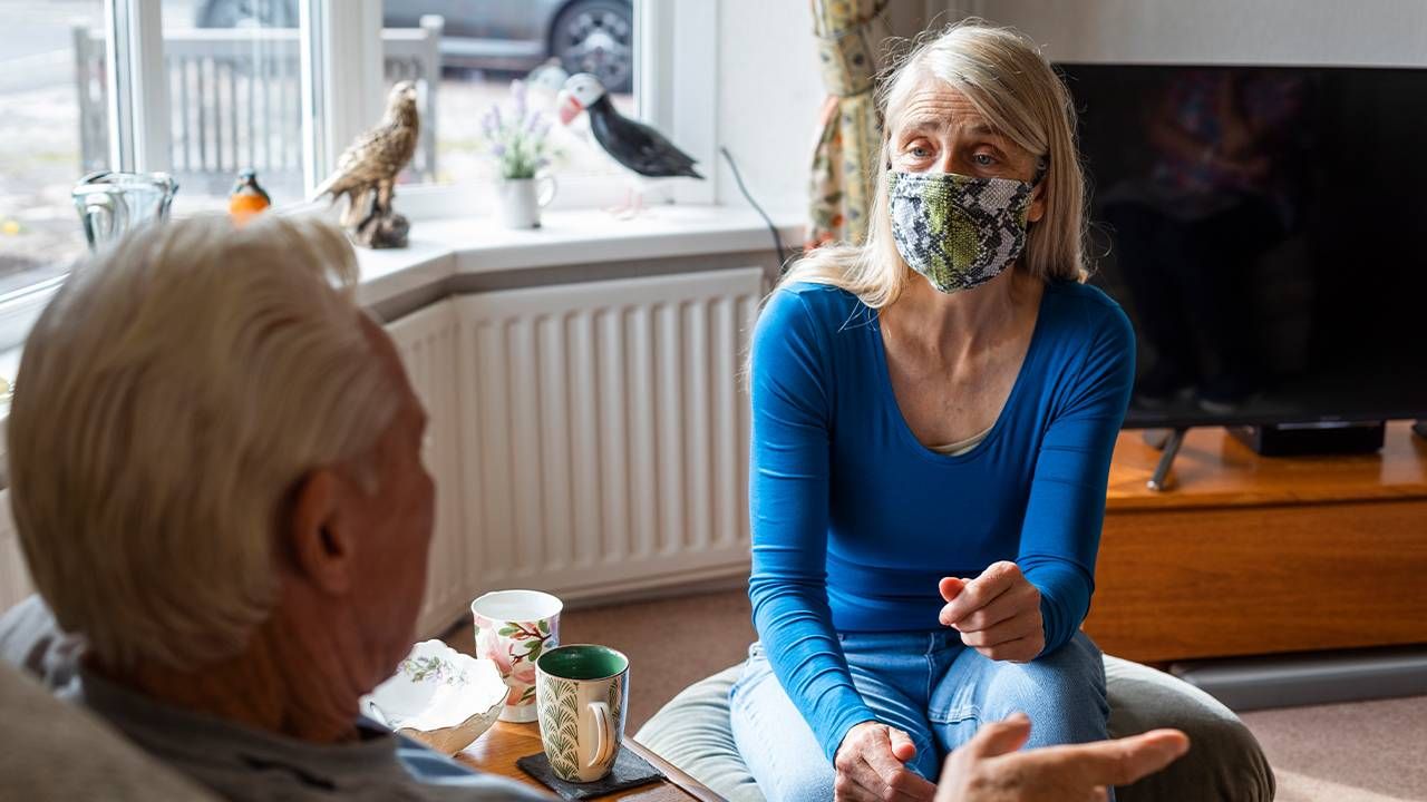 Two older adults talking to each other at home. Next Avenue, long-haul covid headaches, fatigue, financial assistance