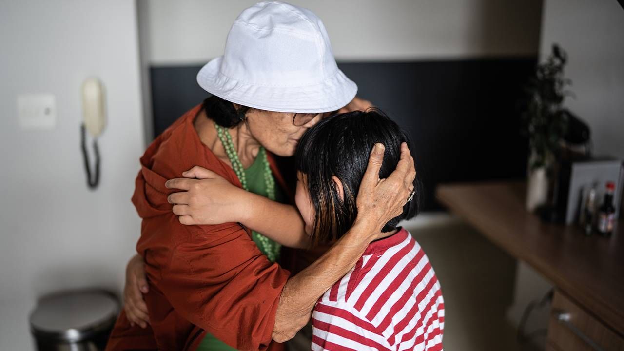 A grandparent being hugged at home by her grandchildren. Next Avenue,