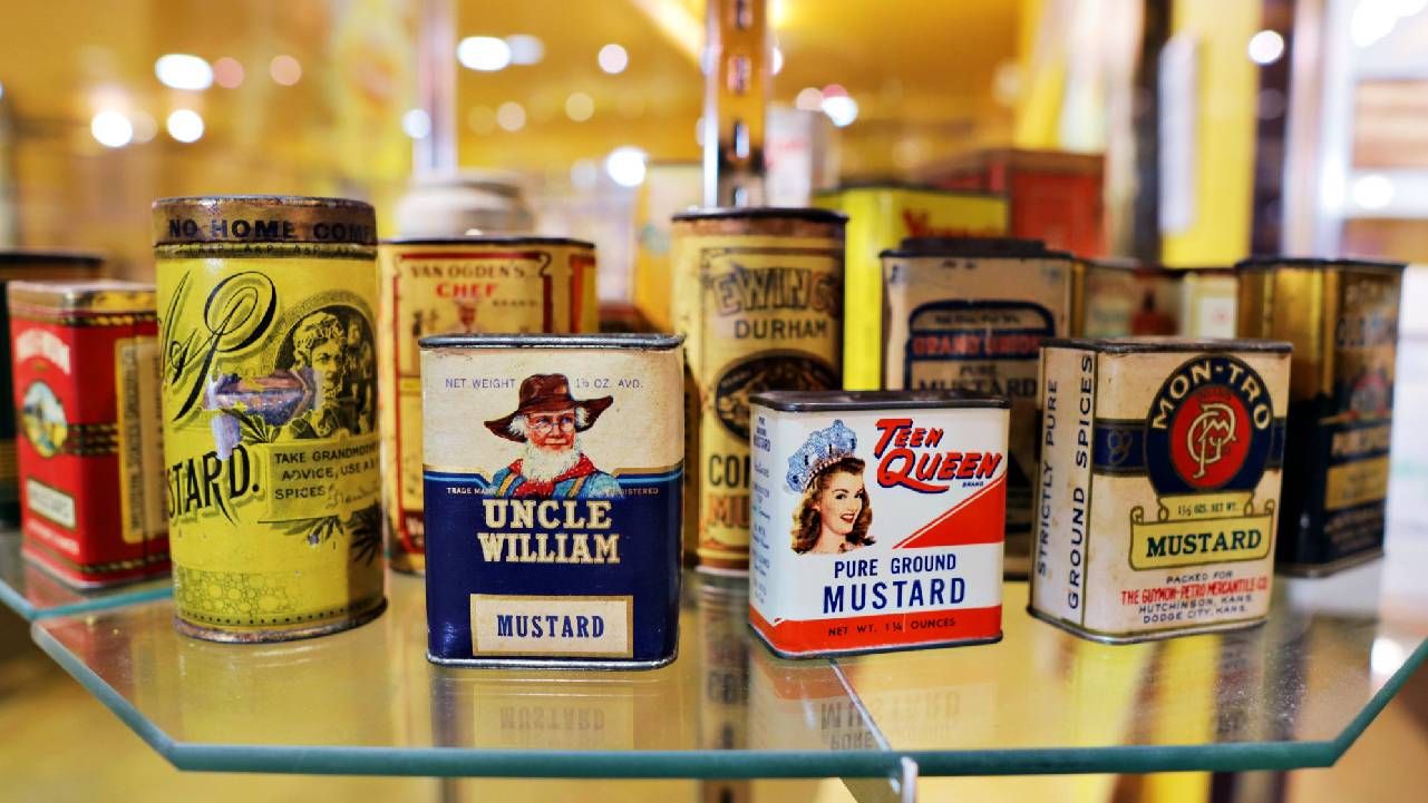 A collection of old mustard tins on a shelf. Next Avenue, quirky collections, museums