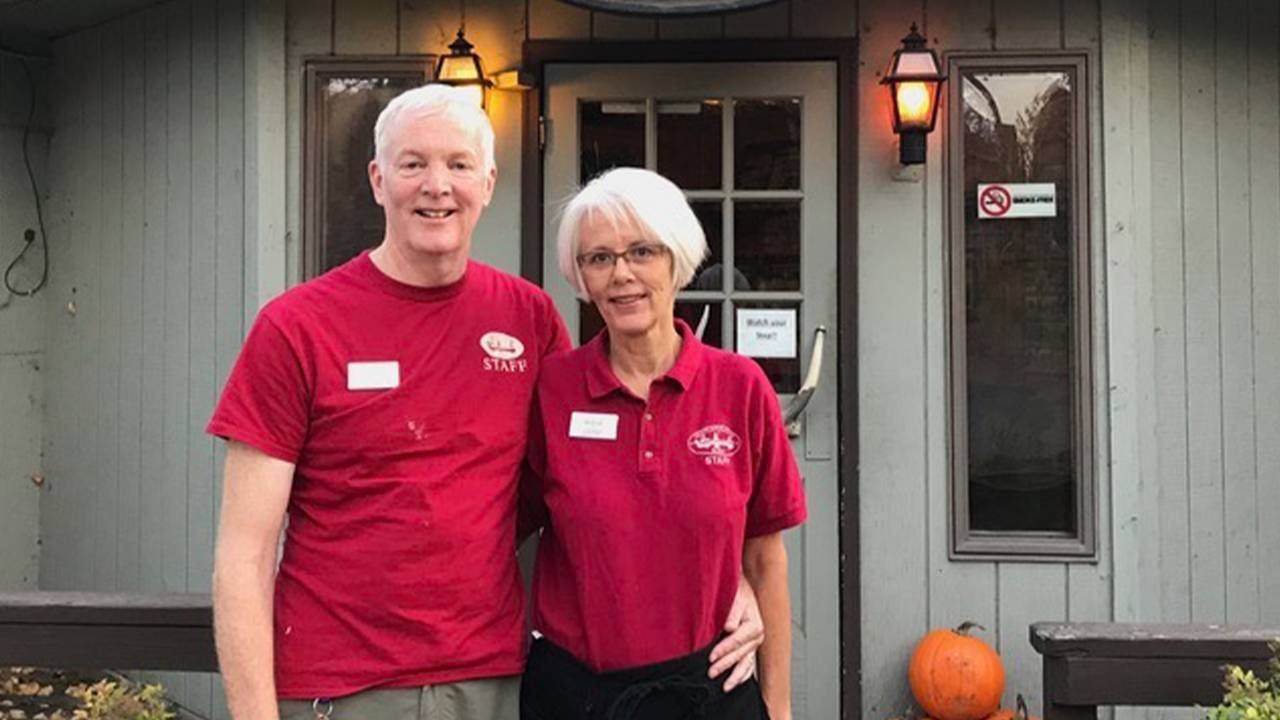 A couple standing in front of a lodge. Next Avenue, retirement travel