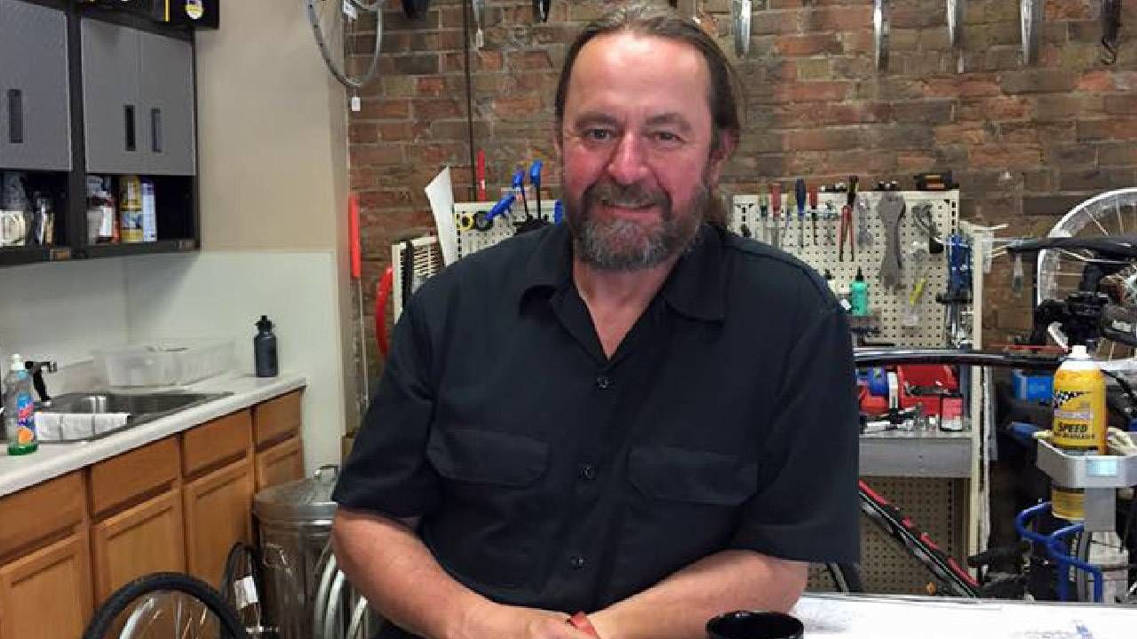 A man smiling inside a bike store. Next Avenue, career change, shift