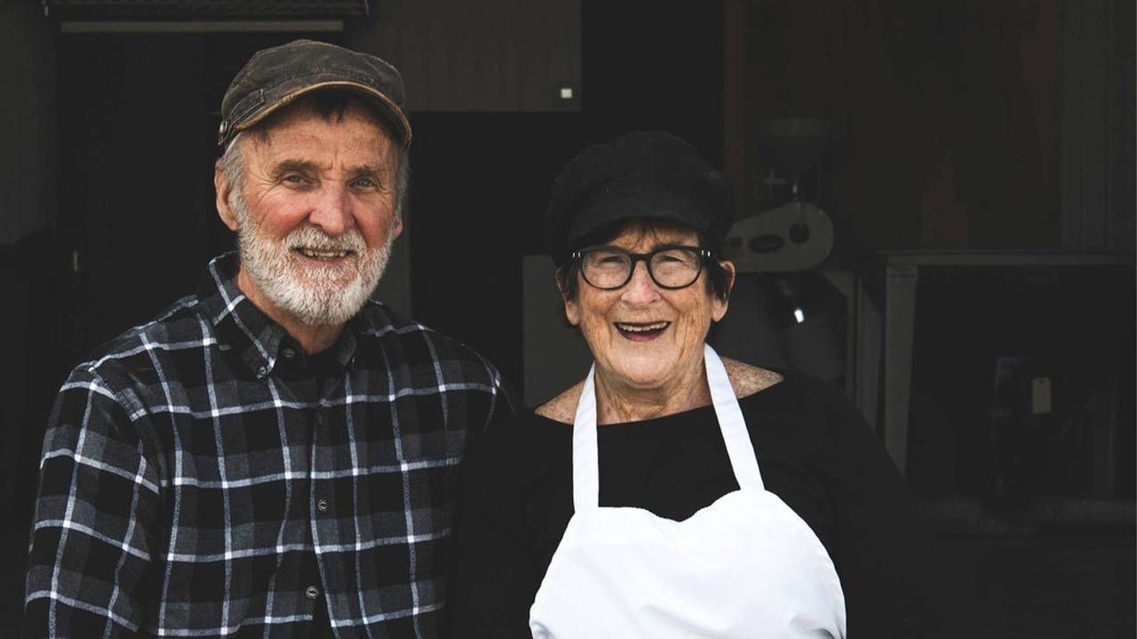 Two bakers sitting side-by-side smiling outside a flour mill. Next Avenue,