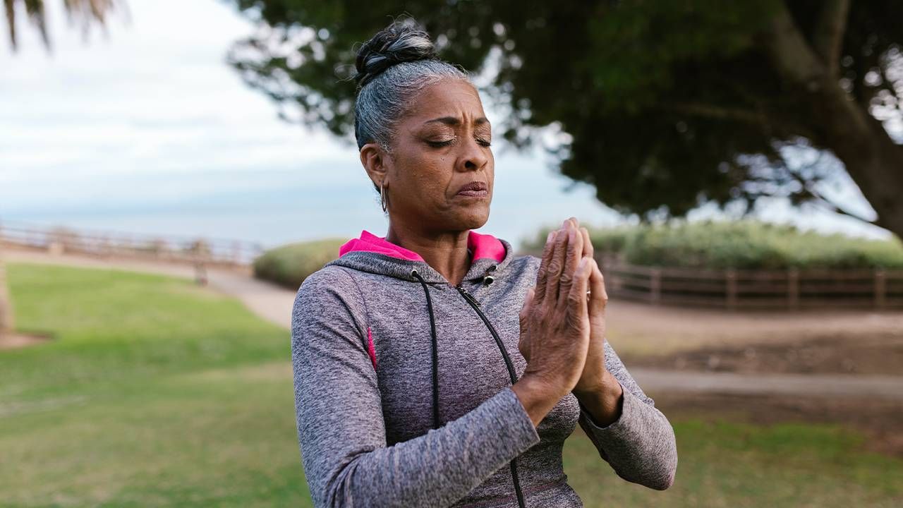 A woman doing yoga in a park. Next Avenue