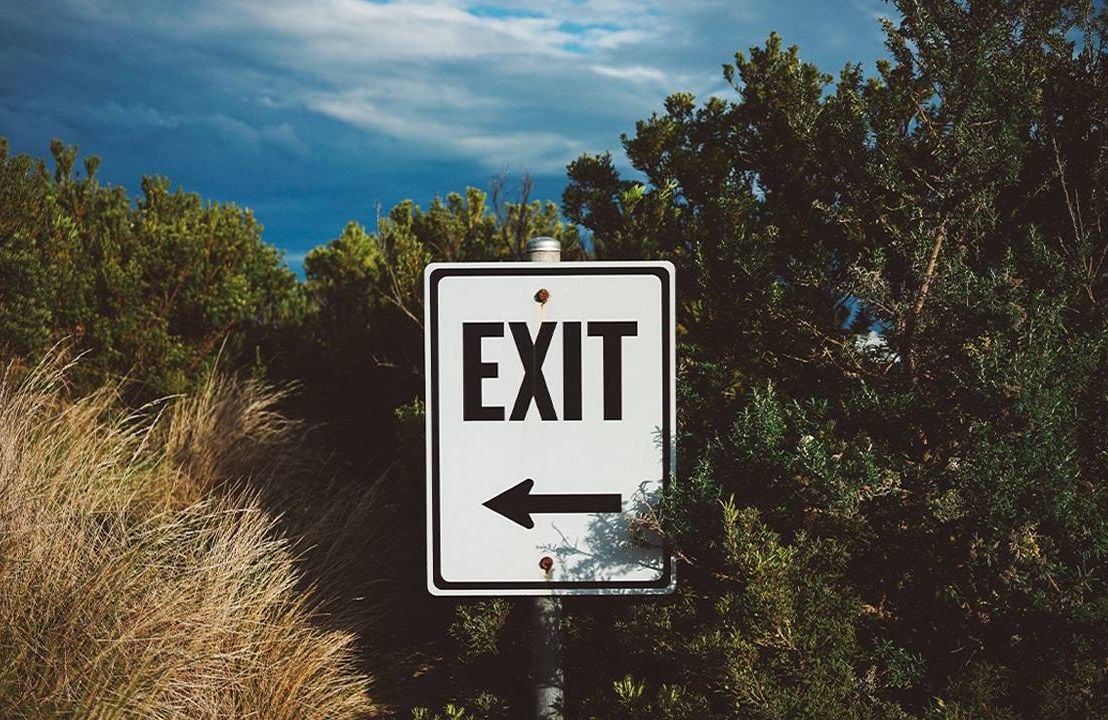 A black and white exit sign at the end of a hiking trail. Next Avenue, how to quit