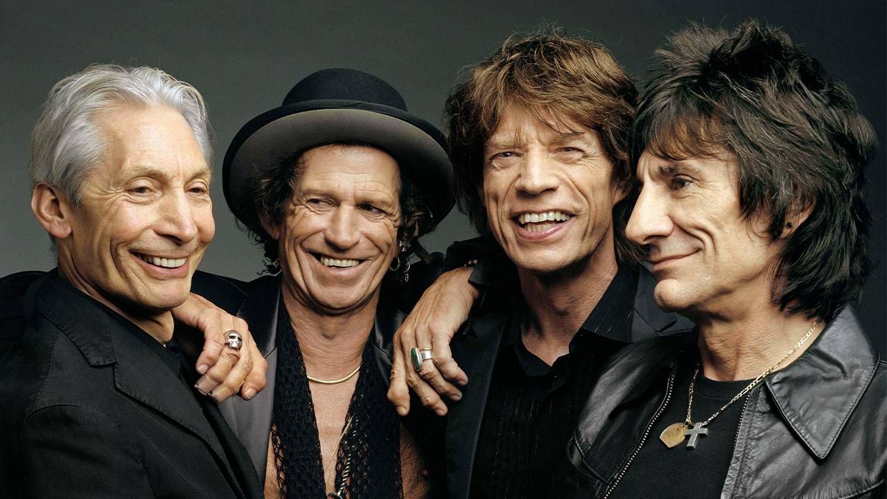 Four members of the Rolling Stones smiling and wearing all black. Next Avenue, the rolling stones 1972 tour