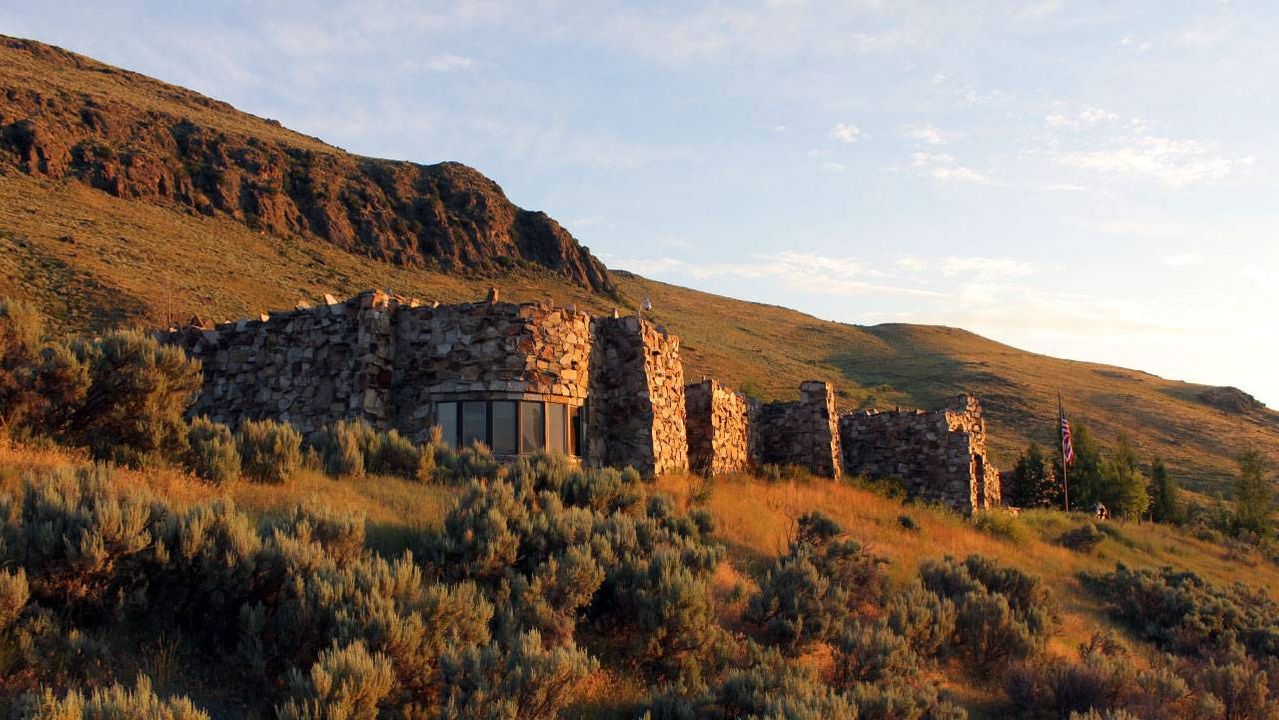 A stone building glowing with light from the sunrise. Next Avenue, National Museum of Wildlife Art