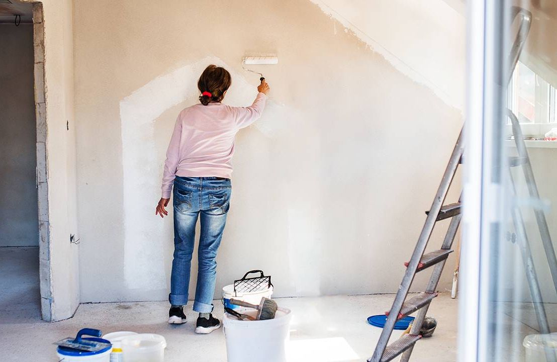 A woman painting the walls of her new house. Next Avenue, Buying a house in midlife, 50+