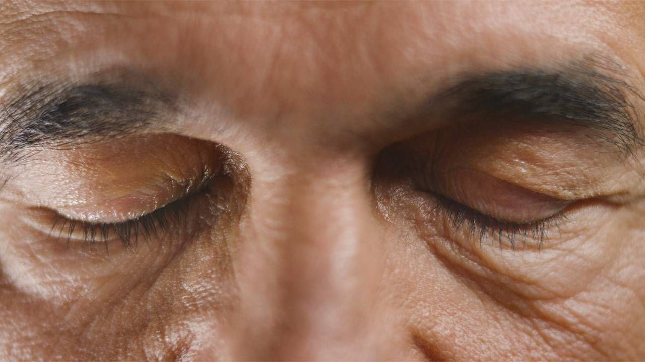 A close-up of an older man's closed eyes. Next Avenue, hypnotherapy benefits
