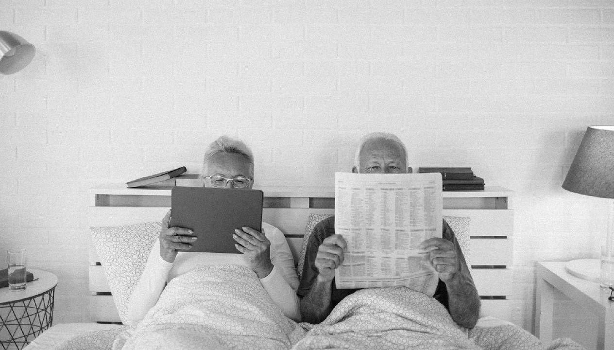 An older couple in bed reading the newspaper. Next Avenue, losing libido aging, low libido