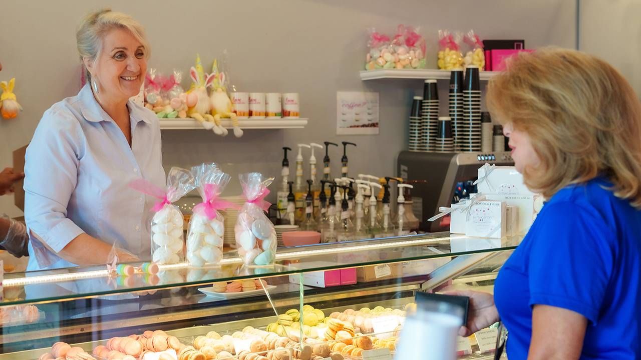 A woman standing behind the counter of her small business. Next Avenue, career shift, second act