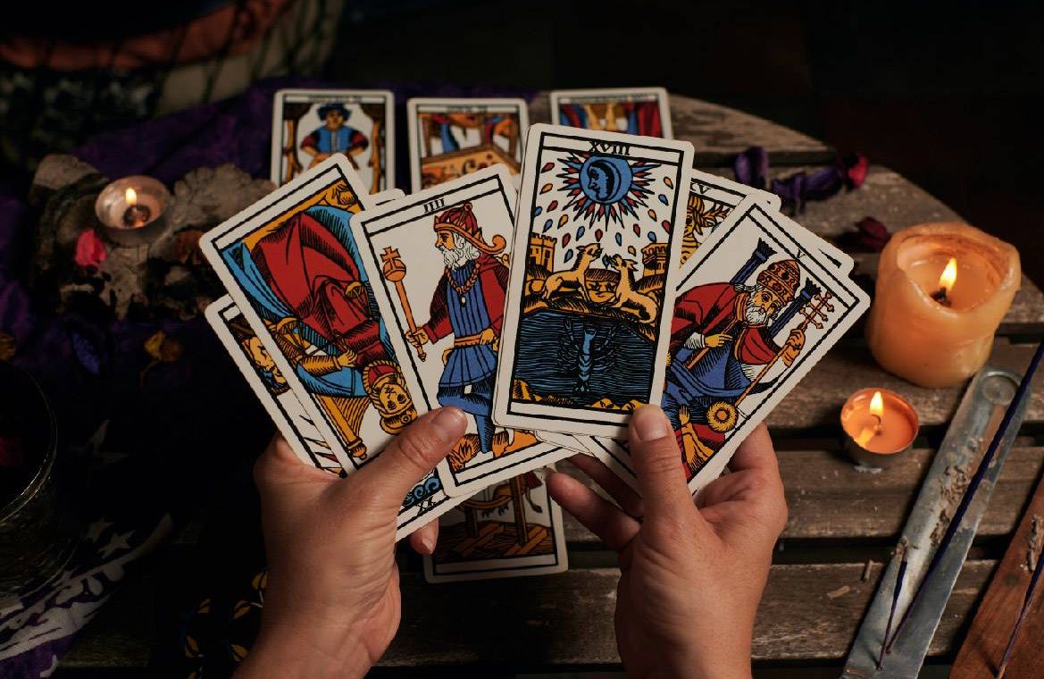A reader holding up tarot cards. Next Avenue, what are tarot cards how do they work