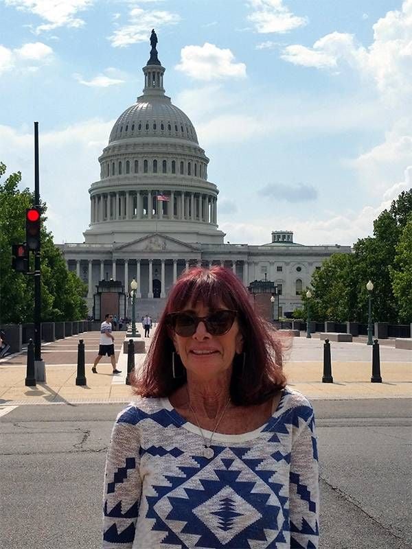 A smiling woman in front of the US Capital building.  Next Avenue, can't afford rent, no steady income, no retirement