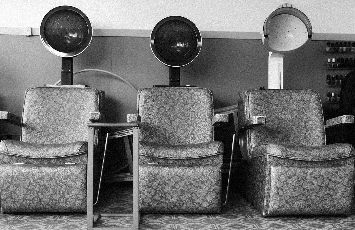 A row of retro hair dryer chairs. Next Avenue