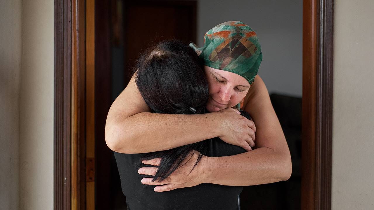 A woman with cancer hugs her friend and caregiver. Next Avenue, becoming caregiver for a friend