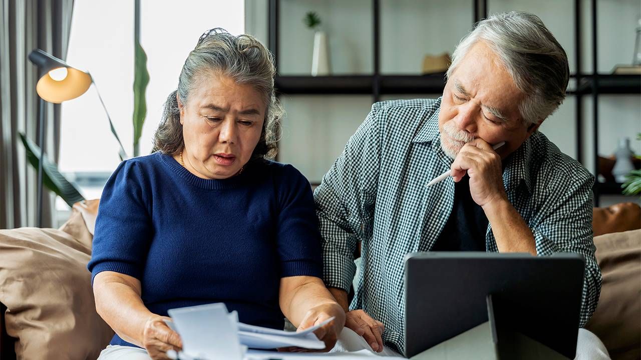 Two older adults looking through paperwork. Next Avenue