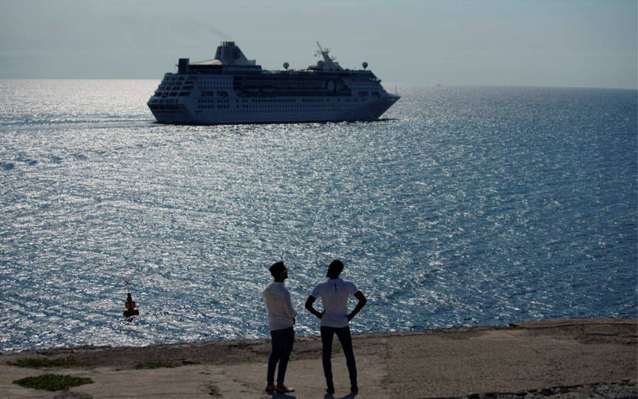Two onlookers watch a cruise vessel departing. Next Avenue, cruise pandemic restrictions, staying safe on a cruise, covid-19 and cruises