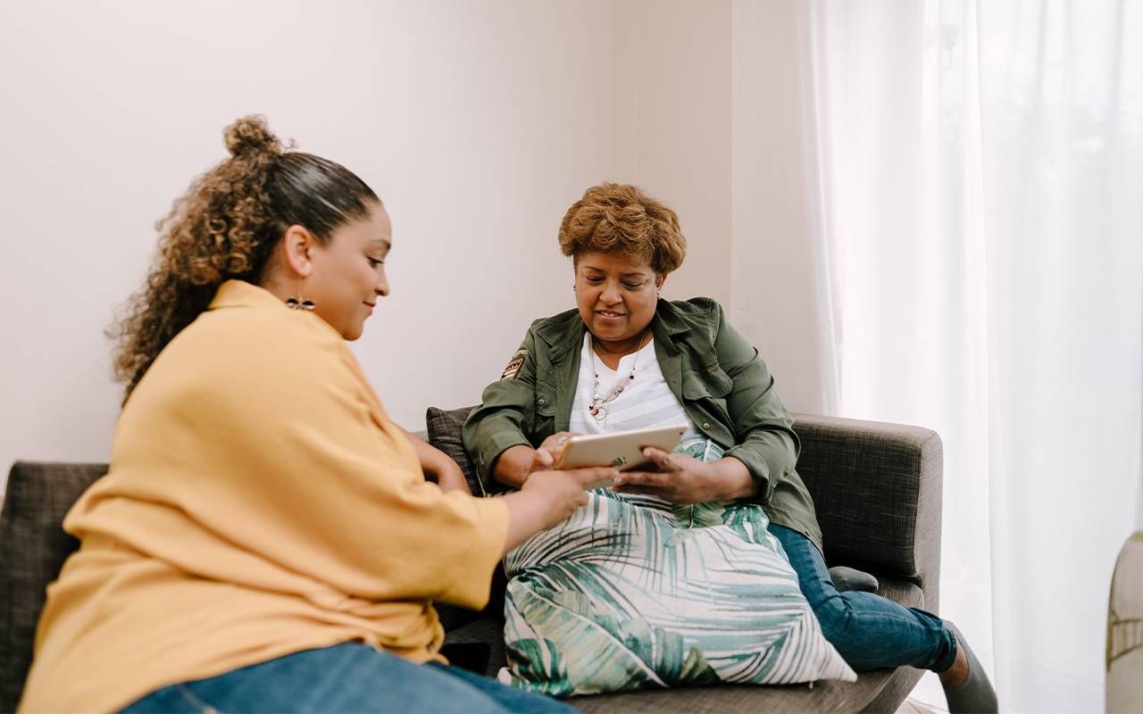 A family caregiver and her mother with dementia sitting with an Ipad. Next Avenue, Memory cafes for dementia