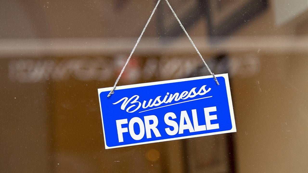 A "business for sale" sign in the door of a business. Next Avenue, selling a business